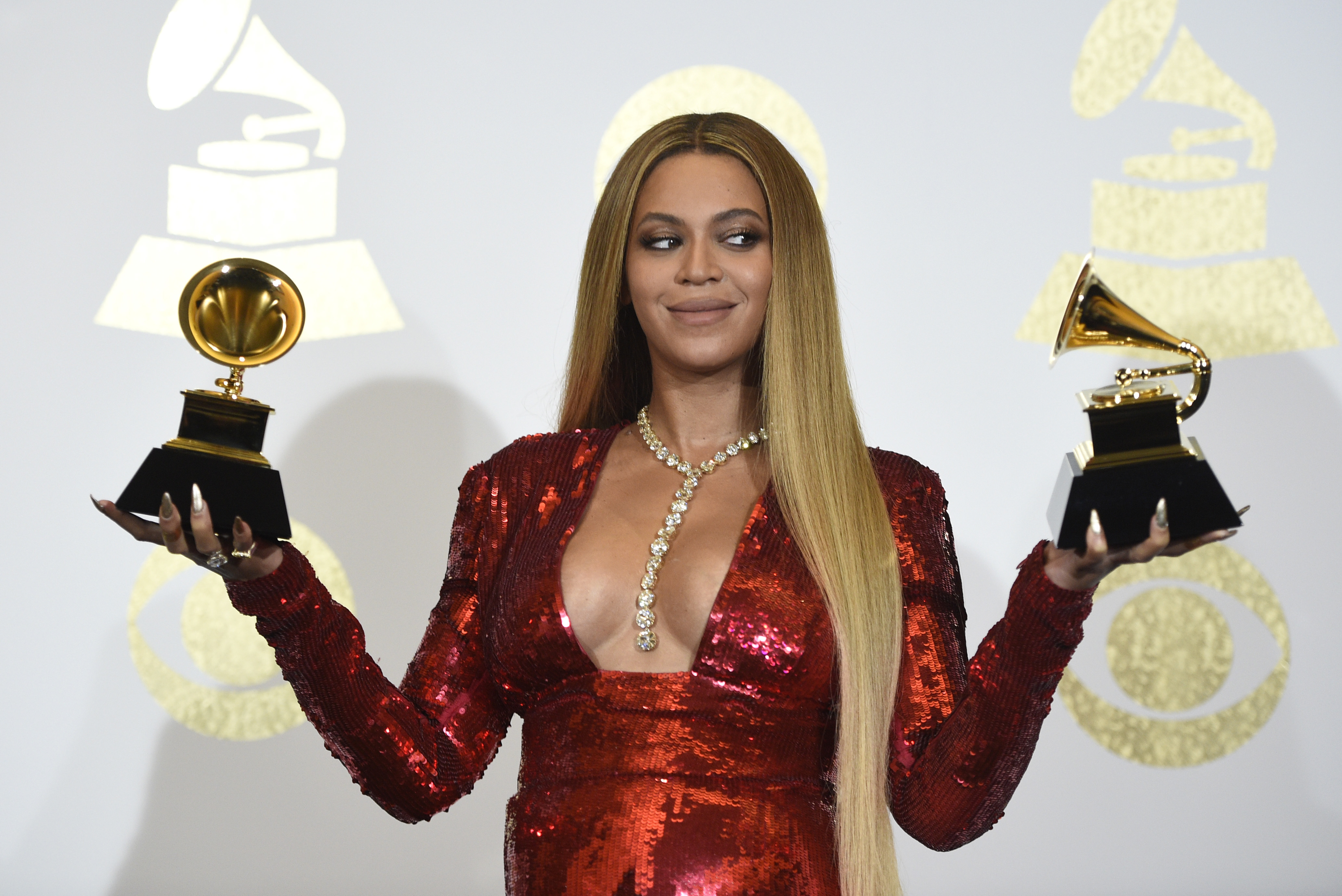 Beyonce poses in the press room with the awards for best music video for 'Formation' and best urban contemporary album for 'Lemonade' at the 59th annual Grammy Awards at the Staples Center  in Los Angeles- AP